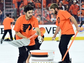 Members of the Philadelphia Flyers Ice Crew pick up wristbands that were thrown onto the ice during the third period against the Washington Capitals in Game 3 of the first round of the NHL playoffs at Wells Fargo Center in Philadelphia on April 18, 2016. (Eric Hartline/USA TODAY Sports)
