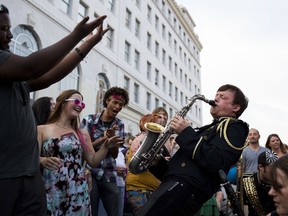 In this Saturday, July 11, 2015 photo, Jeff Richardson plays his saxophone during a solo with the Detroit Party Marching Band during Buckham Alley Fest, a festival showcasing local music, art, food and vendors, in downtown Flint, Mich. The band is part of the lineup for Empty Spaces 8, a three-day music festival opening Thursday in Sarnia. (Danny Miller/The Flint Journal-MLive.com via AP)