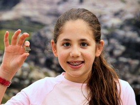 This image released by the Ir David Foundation - City of David on Tuesday, April 19, 2016, shows Neshama Spielman with an ancient Egyptian amulet dating back more than 3,200 years to the days of the Pharaohs discovered by the 12-year-old Israeli girl. (Adina Graham, Ir David Foundation - City of David via AP)