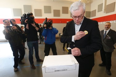 Manitoba NDP Leader and Premier Greg Selinger applies an "I Voted" button after voting in the provincial election in Winnipeg, Tuesday, April 19, 2016. THE CANADIAN PRESS/John Woods