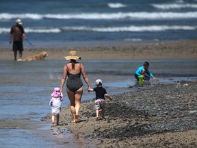 A woman strolls the beach with children while a man pwalks his dog in the surf Monday, April 18, 2016, in Encinitas, Calif. Earth’s record heat streak has hit a record 11 months. The National Oceanic and Atmospheric Administration announced Tuesday, April 19, 2016, that March’s average global temperature of 54.9 degrees was not only the hottest March, but continues a record streak that started last May.(AP Photo/Lenny Ignelzi)