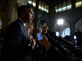 Minister of Finance Bill Morneau speaks to reporters in the foyer of the House of Commons following a cabinet meeting on Parliament Hill in Ottawa on Tuesday, April 19, 2016. THE CANADIAN PRESS/Sean Kilpatrick
