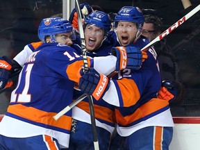 Islanders defenceman Thomas Hickey (centre) celebrates after scoring the game-winning goal against the Panthers with teammates Shane Prince (left) and Josh Bailey (right) in overtime of Game 3 of their first round playoff series at Barclays Center in Brooklyn, N.Y., on Sunday, April 17, 2016. (Brad Penner/USA TODAY Sports)