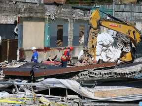 Inspectors on scene a day after a wall collapsed during demolition on Eglinton Ave. W. near Bathurst, Tuesday April 19, 2016. (Dave Abel/Toronto Sun)