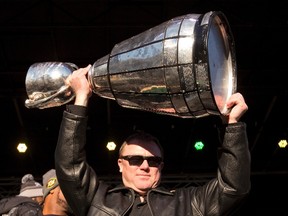 Chris Jones, shown here hoisting the Grey Cup at the downtown Edmonton rally in November, will take the trophy to his hometown. (The Canadian Press)