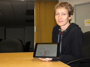 Eileen Kotowich, the farmers market specialist for the province, holds up her iPad displaying the Farmers' Market mobile app, which was released earlier this month.