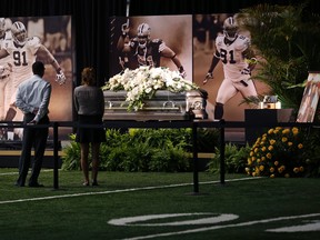 People view the casket of New Orleans Saints defensive end Will Smith during a public viewing inside the Saints training facility in Metairie, La., Friday, April 15, 2016. (AP Photo/Gerald Herbert)