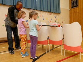 Ottawa Redblacks quarterback Henry Burris takes part in a teeth brushing demonstration at Elizabeth Park Public School in Ottawa Wednesday April 20, 2016. Burris took part in a student assembly on how to properly brush your teeth as part of oral health month in April. Brushing along with Henry is students Maria and Peyton.