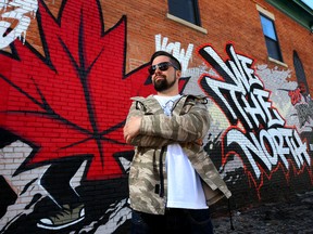 Artist Phil Laporte poses for a photo in front of his mural at 792 Bank Street in Ottawa.