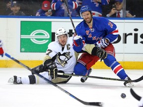 Pittsburgh Penguins centre Sidney Crosby (87) passes the puck around New York Rangers centre Dominic Moore (28) Tuesday at Madison Square Garden. (Brad Penner/USA TODAY Sports)