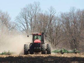 Adam Robson of Ilderton is framed by kicked up dust as he cultivates a field in preparation for planting corn just north of London, Ont. on Wednesday April 20, 2016. (MIKE HENSEN, The London Free Press)