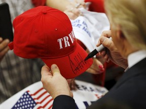 U.S. Republican presidential candidate Donald Trump signs a red trucker hat at a campaign event at the Indiana State Fairgrounds in Indianapolis, Indiana April 20, 2016. (REUTERS/Aaron P. Bernstein)