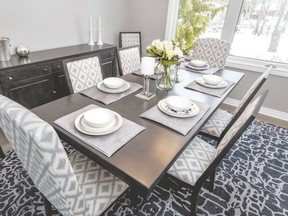 This dining room features a large area rug with navy and pale blues. The dining chairs incorporate two different styles, finished with a patterned fabric to add texture and personality to the space. (Designer: Cassandra Nordell/Copyright William Standen Co. 2016)