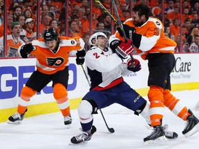 Flyers' Colin McDonald (right) and Capitals' Matt Niskanen (centre) collide as Ryan White (left) skates past during the second period of Game 4 in the first round of the NHL playoffs in Philadelphia on Wednesday, April 20, 2016. (Matt Slocum/AP Photo)