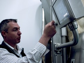 Stuart Marshall, Robotic milking specialist for GEA Canada, points to the Monobox's display that shows farmers the quality result per quarter of the cow while its being milked in real time. (BRUCE CHESSELL/Sentinel-Review)