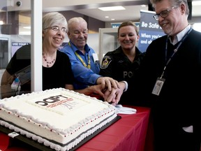 Former OCIPT Chair Lorna Boratto, OCIPT volunteer Ernie Guy, Woodstock police const. Nikki VanLeuwen and MTO member Sean Wright (from left to right) cut into the cake celebrating the 20th anniversary of OCIPT. (BRUCE CHESSELL/Sentinel-Review)