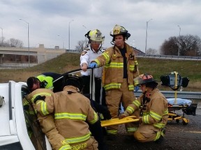 Sarnia firefighters work to free a woman from a vehicle Thursday morning on the side of an on-ramp to Highway 402, at Christina Street in Sarnia, following a single-vehicle accident. The woman was taken to hospital with unknown injuries, according to Lambton OPP. Photo provided by Mike Otis of Sarnia Fire Rescue. (Handout/Sarnia Observer/Postmedia Network)