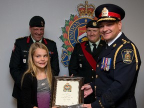 London police chief John Pare presents Marayah Bailey with a commendation Thursday after the sixth-grader replaced a Windsor veteran?s stolen Canadian flag. (DEREK RUTTAN, The London Free Press)