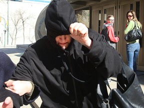 Andrea Giesbrecht tries to hide from the media as she leaves the Law Courts earlier this year. Giesbrecht is charged with concealment after the bodies of six infants were found in a storage locker. (FILE PHOTO)
