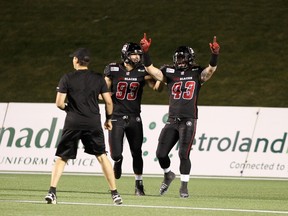 Defensive lineman Justin Capicciotti #93 and linebacker Travis Brown #43 of the Ottawa Redblacks celebrate the first touchdown of the game against the Winnipeg Blue Bombers during a CFL game at TD Place Stadium on October 3, 2014 in Ottawa, Ontario, Canada.  (Photo by Jana Chytilova/Freestyle Photography/Getty Images)