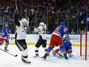 Pittsburgh Penguins center Sidney Crosby, left, and right wing Patric Hornqvist celebrate a goal by Hornqvist against New York Rangers goalie Henrik Lundqvist during the first period of Game 4 of an NHL hockey first-round Stanley Cup playoff series. (AP Photo/Julie Jacobson)