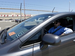 In this July 15, 2015 file photo, Uber driver Karim Amrani sits in his car parked near the San Francisco International Airport parking area in San Francisco. Uber says it has settled a pair of major class-action lawsuits in California and Massachusetts that will keep its drivers independent contractors instead of employees. The settlement announced by the ride-hailing company Thursday night, April 21, 2016, is a major step toward keeping its current thriving business model that has been threatened as drivers sought more rights. (AP Photo/Jeff Chiu, File)