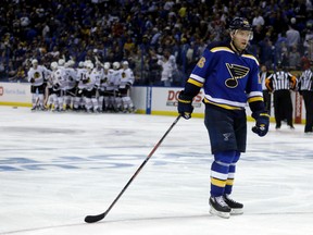 St. Louis Blues' Paul Stastny skates on the ice as members of the Chicago Blackhawks gather around teammate Patrick Kane in the background after he scored the game-winning goal during the second overtime in Game 5 of an NHL hockey first-round Stanley Cup playoff series early Friday, April 22, 2016, in St. Louis. The Blackhawks won 4-3. (AP Photo/Jeff Roberson)