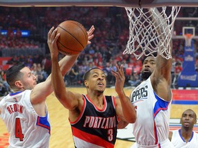 Portland Trail Blazers guard C.J. McCollum (middle) shoots as Los Angeles Clippers guard J.J. Redick and centre DeAndre Jordan defend the basket Wednesday, April 20, 2016, in Los Angeles. (AP Photo/Mark J. Terrill)