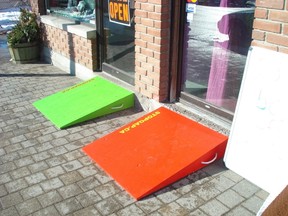Brightly coloured, temporary wooden ramps for single step storefronts are made from donated material.