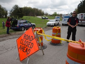 Media and emergency personnel stand at the perimeter of a crime scene as investigation vehicles drive up Union Hill Road, Friday, April 22, 2016, in Pike County, Ohio. Shootings with multiple fatalities were reported along a road in rural Ohio on Friday morning, but details on the number of deaths and the whereabouts of the suspect or suspects weren't immediately clear. The attorney general's office said a dozen Bureau of Criminal Investigation agents had been called to Pike County, an economically struggling area in the Appalachian region some 80 miles east of Cincinnati. (AP Photo/John Minchillo)