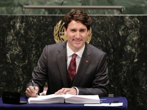 Justin Trudeau, Prime Minister of Canada, signs the Paris Agreement on climate change, Friday, April 22, 2016 at U.N. headquarters. (AP Photo/Mark Lennihan)