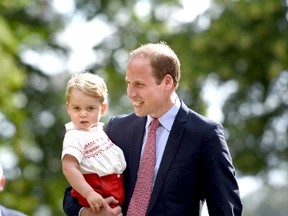 Britain's Prince William holds his son Prince George as they walk past the crowds after the christening of his daughter Princess Charlotte at the Church of St Mary Magdalene on the Sandringham Estate, July 5, 2015.    REUTERS/Mary Turner