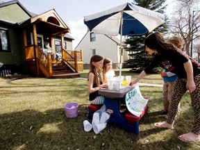 Ryver Hanson, 8, (left at table) and Harleigh Shave, 7, sell lemonade to kids in their North Glenora neighbourhood, in Edmonton, Alta. The two girls plan on donating the money they make to charity, but haven’t decided which charity yet.