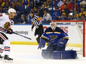 Blues goalie Brian Elliott (right) keeps his eye on the puck after blocking a shot by Blackhawks centre Jonathan Toews (left) during first period NHL playoff action in St. Louis on Thursday, April 21, 2016. (Billy Hurst/USA TODAY Sports)