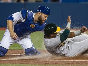 Blue Jays catcher Russell Martin puts the tag on Khris Davis of the A’s during Friday night's game at the Rogers Centre. (CRAIG ROBERTSON/TORONTO SUN)