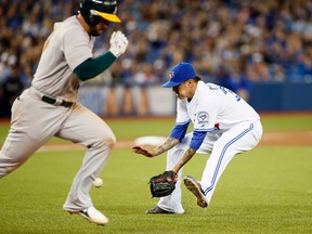 Toronto Blue Jays pitcher Jesse Chavez (30) picks up a ground ball hit by Oakland Athletics first baseman Yonder Alonso (17) in the eighth inning at Rogers Centre. Oakland defeated Toronto 8-5. (John E. Sokolowski-USA TODAY Sports)