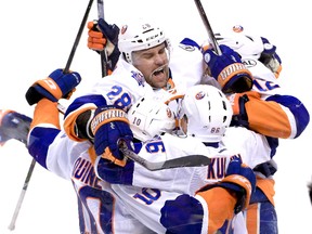Islanders centre Alan Quine (10) celebrates his game winning goal against the Panthers with left wing Josh Bailey (12), defenceman Marek Zidlicky (28) and left wing Nikolay Kulemin (86) in the second overtime of Game 5 of the first round playoff series in Sunrise, Fla., on Friday, April 22, 2016. (Robert Mayer/USA TODAY Sports)