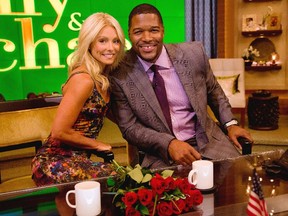 Former football player Michael Strahan, right, poses Kelly Ripa on the set of the newly named "Live! with Kelly and Michael" on Tuesday, Sept. 4, 2012 in New York. (Photo by Charles Sykes/Invision/AP Images)
