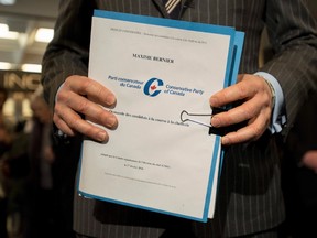 Conservative MP Maxime Bernier holds documents as he speaks to reporters outside the offices of the Conservative Party of Canada as he officially launches his bid for the leadership of the party, on Thursday, April 7, 2016 in Ottawa. THE CANADIAN PRESS/Justin Tang