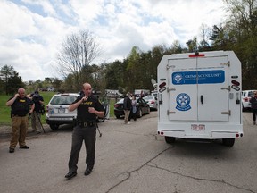 Authorities allow crime scene investigation vehicles to pass a perimeter checkpoint near a crime scene, Friday, April 22, 2016, in Pike County, Ohio. Shootings with multiple fatalities were reported along a road in rural Ohio on Friday morning, but details on the number of deaths and the whereabouts of the suspect or suspects weren't immediately clear. The attorney general's office said a dozen Bureau of Criminal Investigation agents had been called to Pike County, an economically struggling area in the Appalachian region some 80 miles east of Cincinnati. (AP Photo/John Minchillo)
