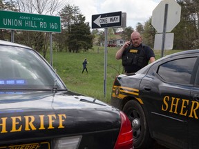 Authorities create a perimeter near a crime scene on Union Hill Rd, Friday, April 22, 2016, in Pike County, Ohio. Shootings with multiple fatalities were reported along a road in rural Ohio on Friday morning, but details on the number of deaths and the whereabouts of the suspect or suspects weren't immediately clear. The attorney general's office said a dozen Bureau of Criminal Investigation agents had been called to Pike County, an economically struggling area in the Appalachian region some 80 miles east of Cincinnati. (AP Photo/John Minchillo)