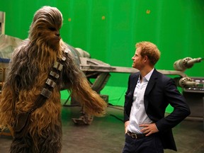 Britain's Prince Harry meets Chewbacca during a visit to the Star Wars film set at Pinewood Studios near Iver Heath, west of London, Britain, April 19, 2016. Prince William and Prince Harry are touring Pinewood to visit the production workshops and meet the creative teams working behind the scenes on the Star Wars films. REUTERS/Adrian Dennis/Pool