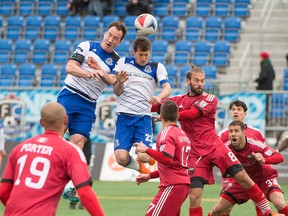 FC Edmonton players Albert Watson and Jake Keegan go up for the ball during a corner kick in Sunday's match against the Ottawa Fury. (Shaughn Butts)
