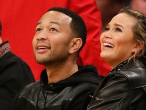 FILE - In a Thursday, March 10, 2016 file photo, musician John Legend, left, and model Chrissy Teigen, right, sit courtside during the first half of an NBA basketball game between the Los Angeles Lakers and Cleveland Cavaliers, in Los Angeles.(AP Photo/Danny Moloshok, File)
