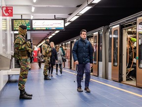 Soldiers patrol as commuters walk on the platform at Maelbeek metro station in Brussels on April 25, 2016. For the first time since the March 22 attacks, all of the Brussels metro lines are operating a full schedule again. (AP Photo/Geert Vanden Wijngaert)