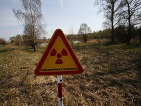 In this photo taken on April 11, 2016, a radiation warning sign is placed near the checkpoint 'Maidan' of the state radiation ecology reserve inside the 30 km exclusion zone around the Chornobyl nuclear reactor, some 370 km (231 miles) south-east of Minsk, Belarus. The sign is placed in 2 km distance of Nikolai Chubenok farm. (AP Photo/Sergei Grits)