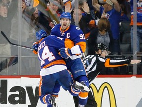 Islanders defenceman Thomas Hickey (14) leaps in the air with teammate John Tavares (91) after Tavares scored the winning goal against the Panthers in the second overtime period of Game 6 of a first-round playoff series in Brooklyn, N.Y., on Sunday, April 24, 2016. (Kathy Willens/AP Photo)