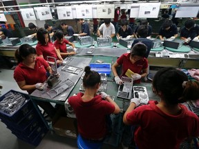 Employees work at a Foxconn factory in Wuhan, Hubei province, in this August 31, 2012 file photograph. Foxconn Technology Group, the assembler of most of the world's top-selling electronic gadgets including Apple Inc's iPhone.  REUTERS/Stringer/Files