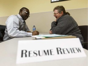 Employment coach Peter Ekekhor (left) gives Karen Chick resume advice during the Resume, Set, Go! Job Search Book Camp at Alberta Works Supports Centre in Edmonton on Monday, April 25, 2016. (Ian Kucerak)
