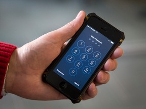 In this Feb. 17, 2016 file photo an iPhone is seen in Washington. FBI Director James Comey said he's unsure if a vulnerability used to unlock an iPhone linked to one of the San Bernardino killers would go through a government review to determine if it should be disclosed to Apple. (AP Photo/Carolyn Kaster, File)